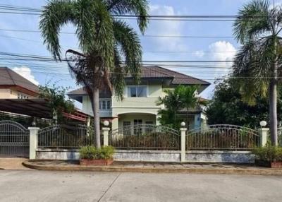 Suburban two-story house with gated fence and palm trees