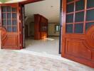 Spacious entrance hall with wooden doors and tiled flooring in a residential property