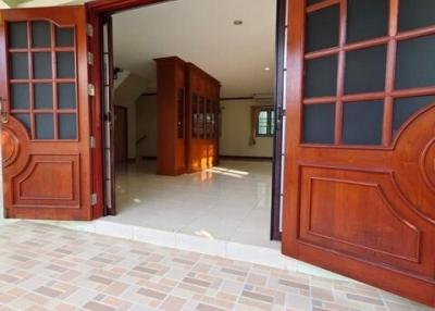 Spacious entrance hall with wooden doors and tiled flooring in a residential property