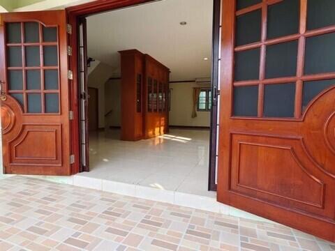 Spacious entrance hall with wooden doors and tiled flooring in a residential property