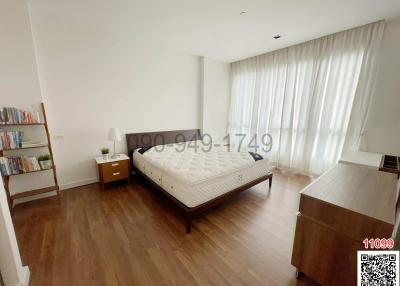 Spacious bedroom with large bed and hardwood floors