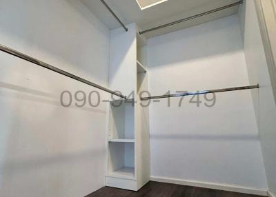 Empty walk-in closet with built-in shelves and hanging rods