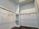 Empty walk-in closet with built-in shelves and hanging rods