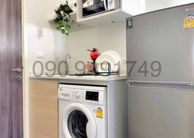 Compact kitchen space with modern appliances and wooden door