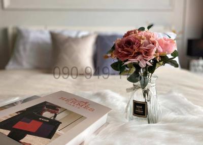 Elegant bedroom with a close-up view of a book and flowers on the bed
