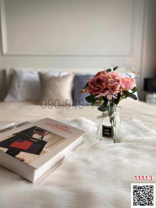 Elegant bedroom with a close-up view of a book and flowers on the bed