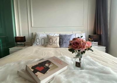 Cozy bedroom interior with a neatly made bed and a bouquet of flowers