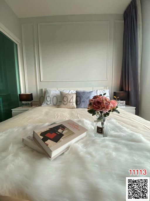 Cozy bedroom interior with a neatly made bed and a bouquet of flowers