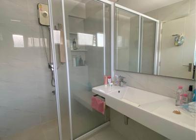 Modern white bathroom with glass shower enclosure and large mirror