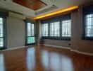 Spacious living room with large windows and hardwood floors