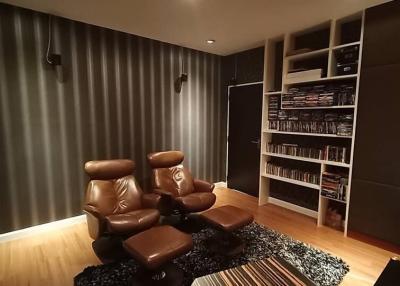Cozy home theater with leather recliners and built-in shelving