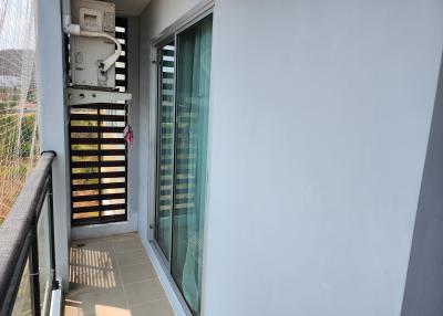 Compact balcony with an air conditioning unit and sliding glass door