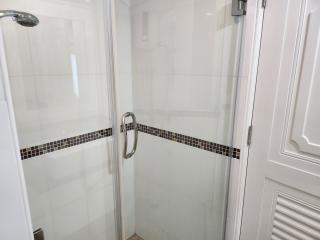 Modern bathroom with glass shower enclosure and white tiling