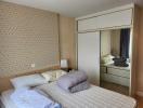 Cozy bedroom with patterned wallpaper and mirrored wardrobe