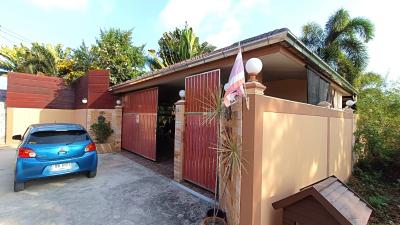 Well-maintained suburban house with a parked car and gated entrance