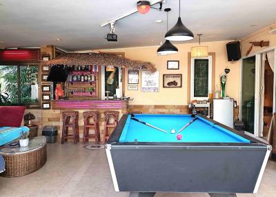 Spacious entertainment room with pool table, bar area, and lounge seating