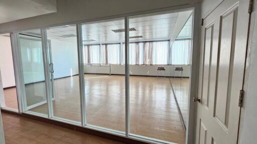 Spacious empty room with large windows and reflective floor