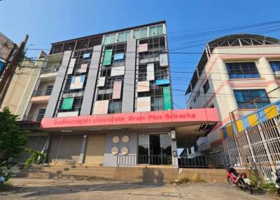 Modern multi-story urban building exterior with commercial space on ground floor