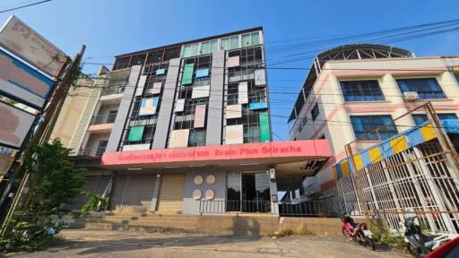 Modern multi-story urban building exterior with commercial space on ground floor