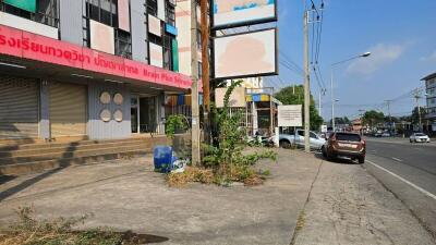 paved area outside commercial buildings with street view