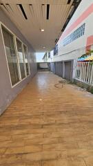 Paved walkway outside a building with a garage door and windows