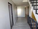 Bright and spacious hallway with modern flooring and black railing