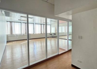 Spacious unfurnished room with large windows and glass partition