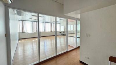 Spacious unfurnished room with large windows and glass partition