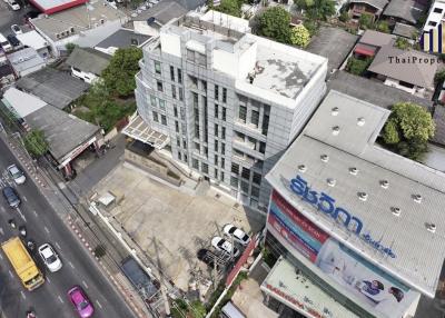 Aerial view of a modern building amidst a bustling urban area