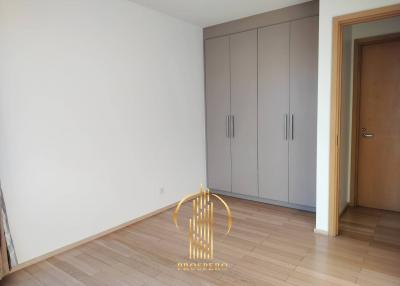 Bright empty bedroom with wooden floor and built-in closet