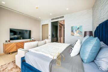 Modern bedroom with stylish interior design, featuring a large bed and a wall-mounted television