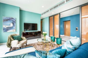 Modern living room interior with vibrant blue accents, artwork, and plush seating