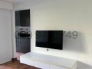 Modern living room interior with mounted television and white entertainment unit