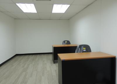 Spacious office space with desks and fluorescent lighting