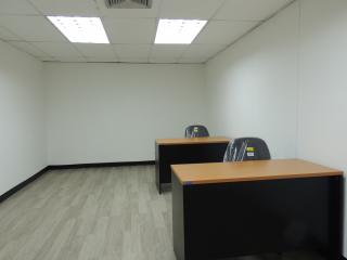 Spacious office space with desks and fluorescent lighting