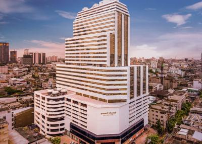 Modern high-rise building exterior against a blue sky with clouds