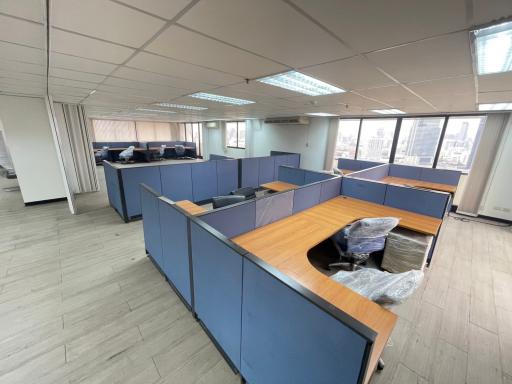 Spacious open-plan office interior with cubicles and city view