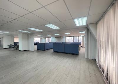 Spacious open-plan office interior with partition panels and large windows