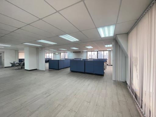 Spacious open-plan office interior with partition panels and large windows