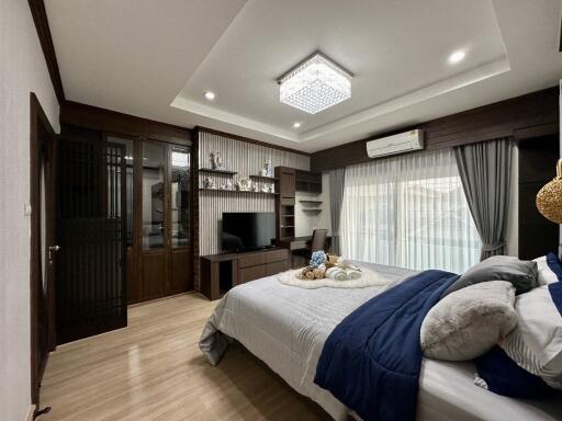 Elegant master bedroom with modern furnishings and built-in wardrobe