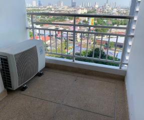 Compact balcony with air conditioning unit and a view of the cityscape