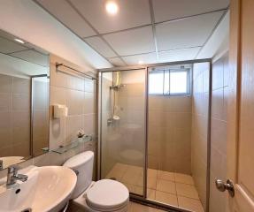 Modern bathroom with glass shower area and beige tiles