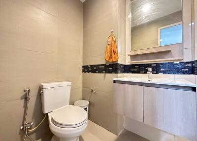 Modern bathroom with beige tiles and blue accents