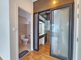 Modern bathroom with frosted glass shower doors and wooden flooring