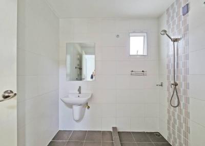 Modern white tiled bathroom with a walk-in shower and window
