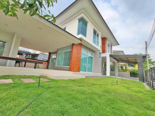 Contemporary two-story house with large windows and a spacious lawn