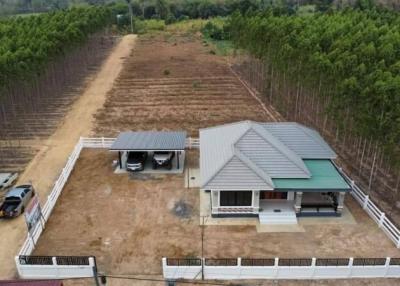 Aerial view of a single-family house with large surrounding land and adjacent orchard