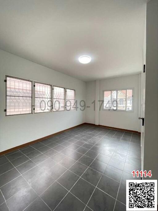 Spacious bedroom with large windows and tiled flooring