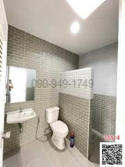 Modern tiled bathroom with shower, toilet, and sink