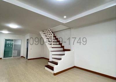 Spacious living room with modern staircase and tiled flooring